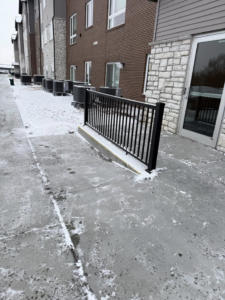 A newly installed black metal railing by Manny's Fence LLC in Omaha, NE, providing safety and style.