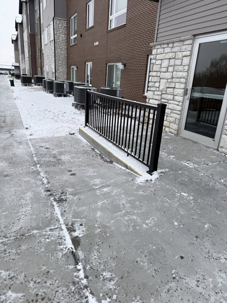 A newly installed black metal railing by Manny's Fence LLC in Omaha, NE, providing safety and style.