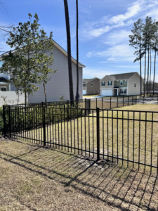 A black metal fence installed in a residential neighborhood by Barwick Fence Company in Savannah, GA.