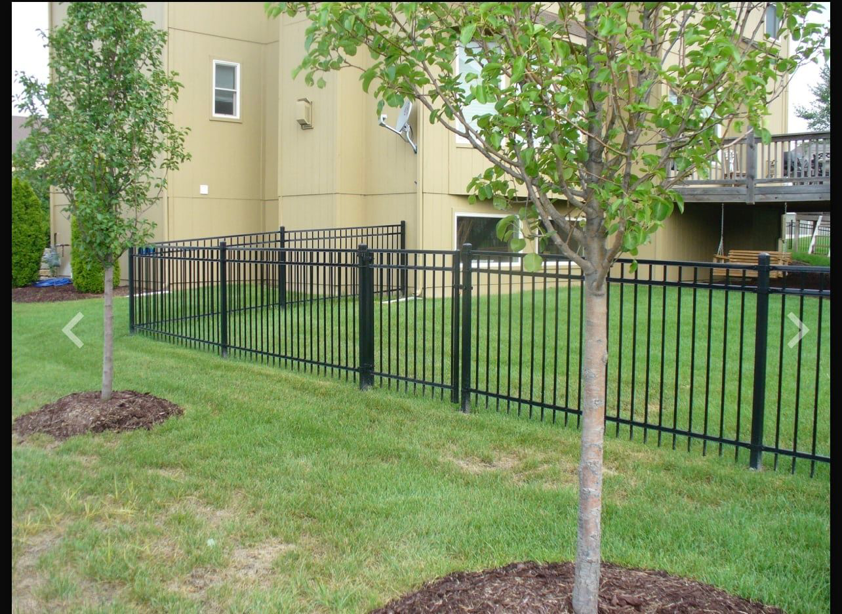A sleek black metal residential fence installed around a backyard by Pokey Fencing & Masonry in Stillwater, OK.