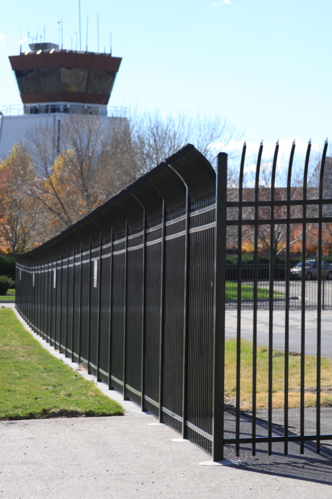 A tall black metal security fence installed around an airport facility by Life Time Fence, Inc. in Cedar Rapids, IA.