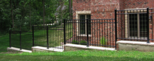 A black metal security fence installed along a brick building by Global Supply in Lindon, UT.