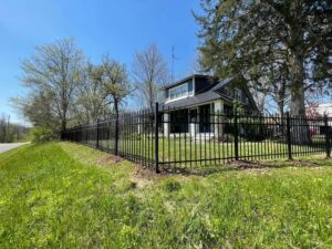 A long black metal security fence installed around a residential property by NBBJ Fence LLC in Bluffton, IN.