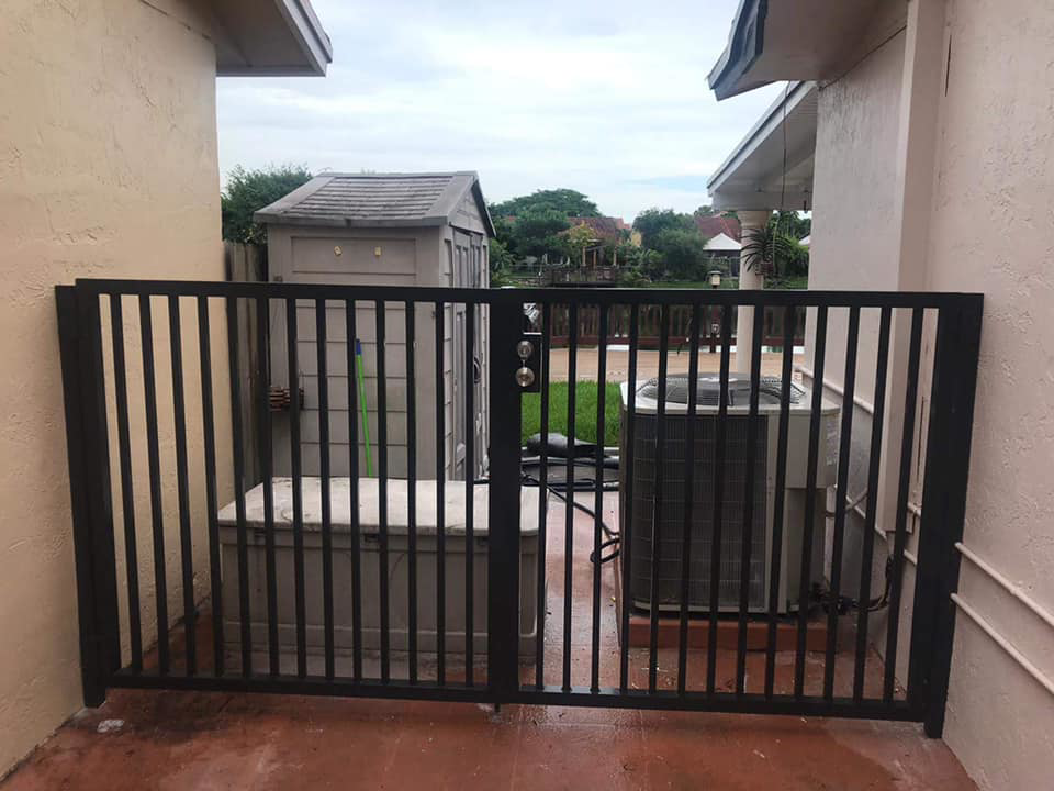 A newly installed black metal security gate by Miami Concrete Fence in Miami, FL