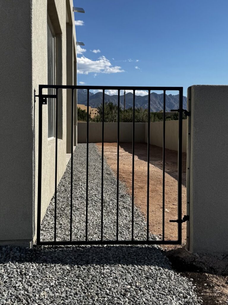 A black metal side yard gate providing access, installed by City Iron LLC in Albuquerque, NM.