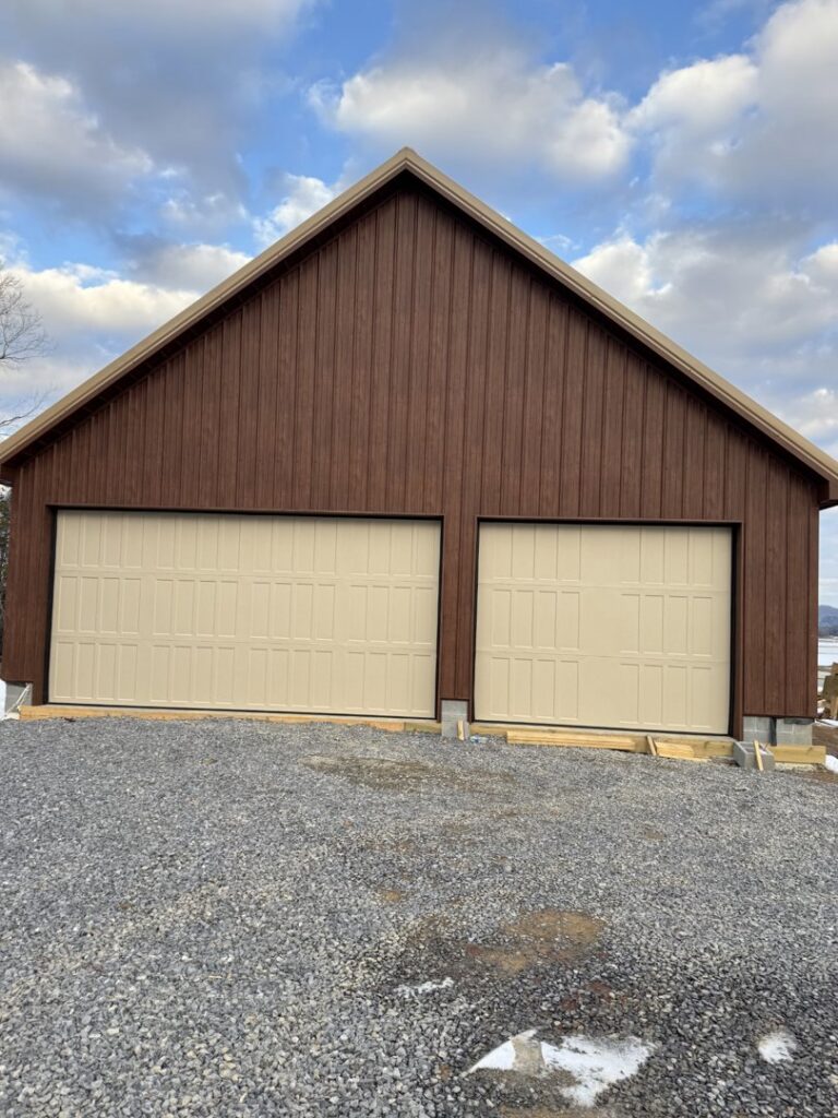 Exterior view of a black modern glass garage door installed on a black-sided building by Skylift Garage Doors - Knoxville, TN