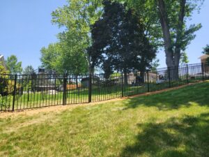 A newly installed black ornamental aluminum fence on a sloped residential backyard by Future Solutions Fence Supply in York, PA