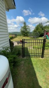 A black ornamental aluminum fence with a gate installed by Quality Fence Inc. in Peekskill, NY.