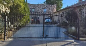 A black ornamental driveway gate installed by Iron Man Exteriors in Las Cruces, NM.