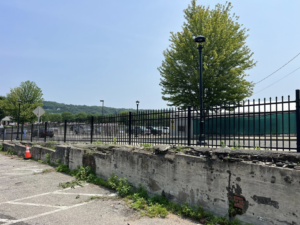 A long black ornamental fence installed along a retaining wall by Oxford Fence Company in Oxford, CT.