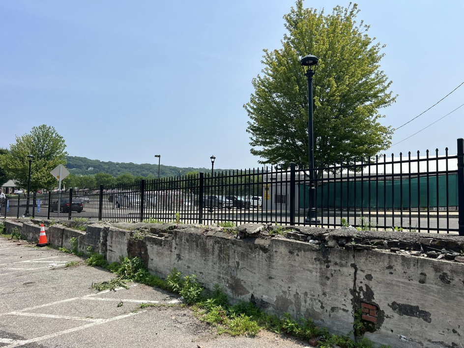 A long black ornamental fence installed along a retaining wall by Oxford Fence Company in Oxford, CT.