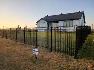 A black ornamental metal fence installed around a modern house by Aces Deck and Fence in Fargo, ND