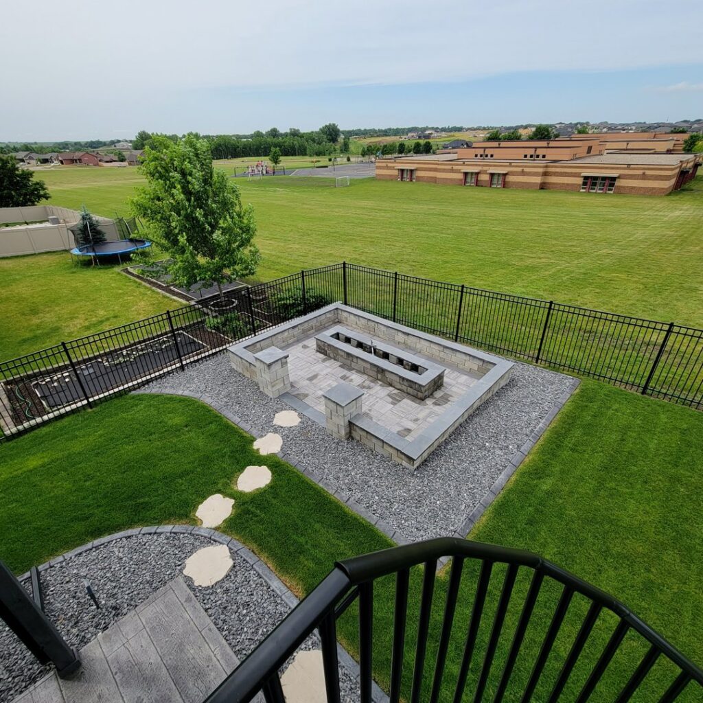 A black ornamental fence enclosing a modern fire pit area by Complete Fence, LLC in West Chicago, IL