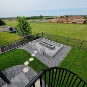 A black ornamental fence enclosing a modern fire pit area by Complete Fence, LLC in West Chicago, IL