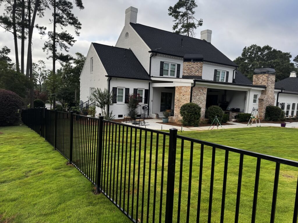 A black ornamental metal fence installed around a large residential home by East Georgia Fence in Evans, GA.
