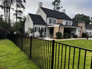 A black ornamental metal fence installed around a large residential home by East Georgia Fence in Evans, GA.