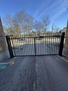 A newly installed black ornamental iron driveway gate by Littleton Construction LLC, enhancing security in the Service Area.