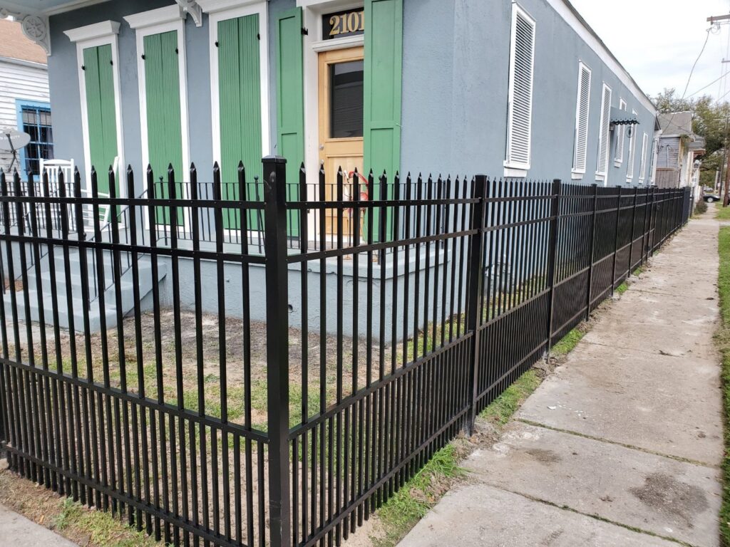 A black ornamental iron fence installed along a sidewalk in front of a house by 5-Alarm Fence Company in New Orleans, LA.