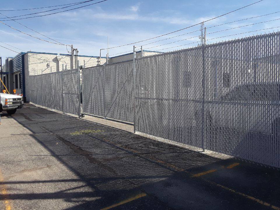 A black ornamental iron fence installed in a backyard with a wooden privacy fence in the background by Best Fence & Gate LLC in Louisville, KY.