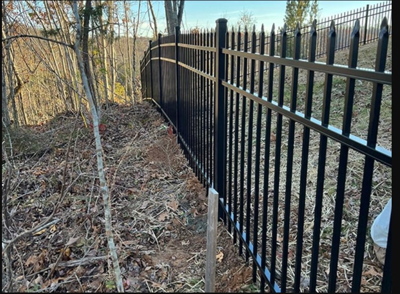A black ornamental iron fence installed on a sloped terrain by Kelley Fence and Gate in Eva, AL.