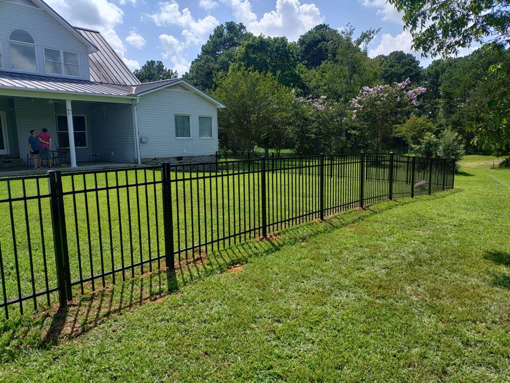 A black ornamental iron fence installed around a residential backyard by Kelley Fence and Gate in Eva, AL.