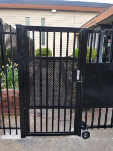 A black ornamental iron gate with a keypad entry system by Stewart & Son Gate & Fence Co. in Hillsboro, OR