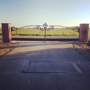 A black ornamental iron sliding gate for a commercial parking lot, installed by The Fence Company in Fresno, CA.