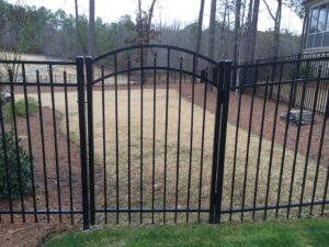 A black ornamental metal fence with an elegant arched gate installed by East Georgia Fence in Evans, GA.