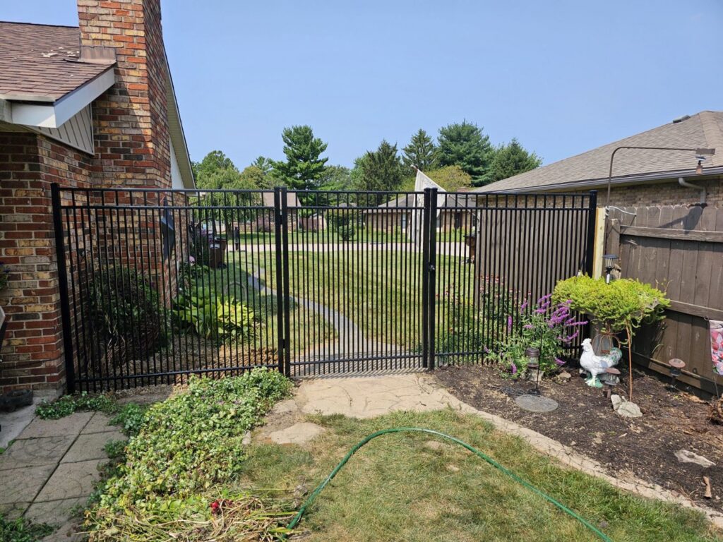 A black ornamental metal fence with a gate installed by Barney's Landscaping in Dayton, OH.