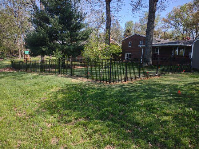 A black ornamental metal fence installed around a large grassy area by Nailed It Fencing and Exteriors in Evansville, IN.