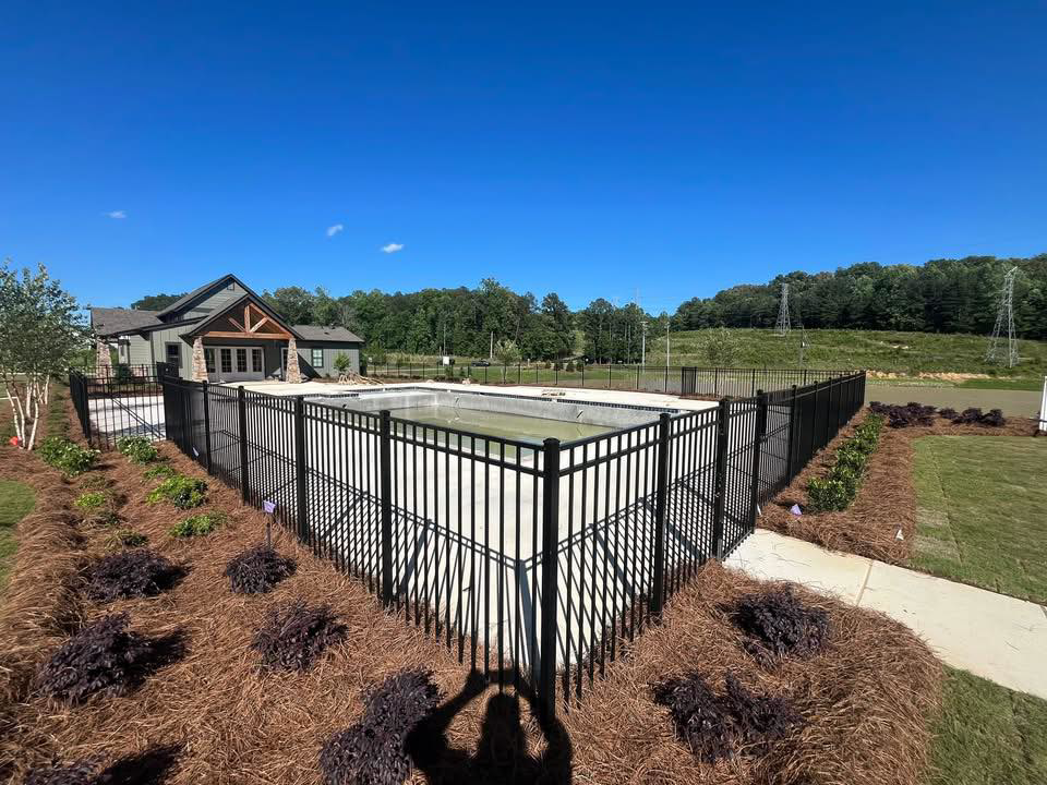 A stylish black ornamental metal fence surrounding a swimming pool area by Alabama Fence & Rail LLC in Birmingham, AL.