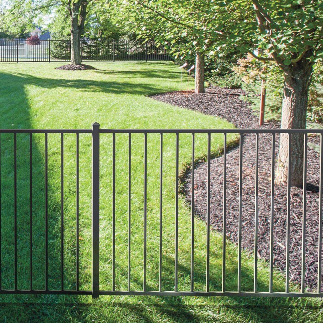 A black ornamental metal fence installed along a property line in a green yard by Western Fence & Landscape Supply in Caldwell, ID.