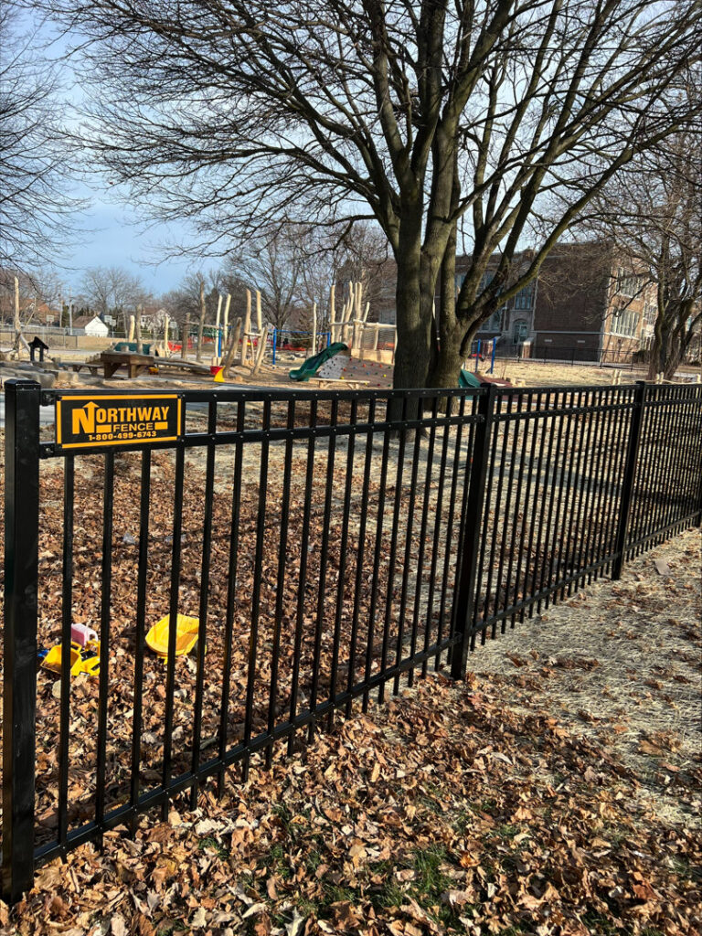 A black ornamental fence surrounding a playground, installed by Northway Fence in Menomonee Falls, WI.