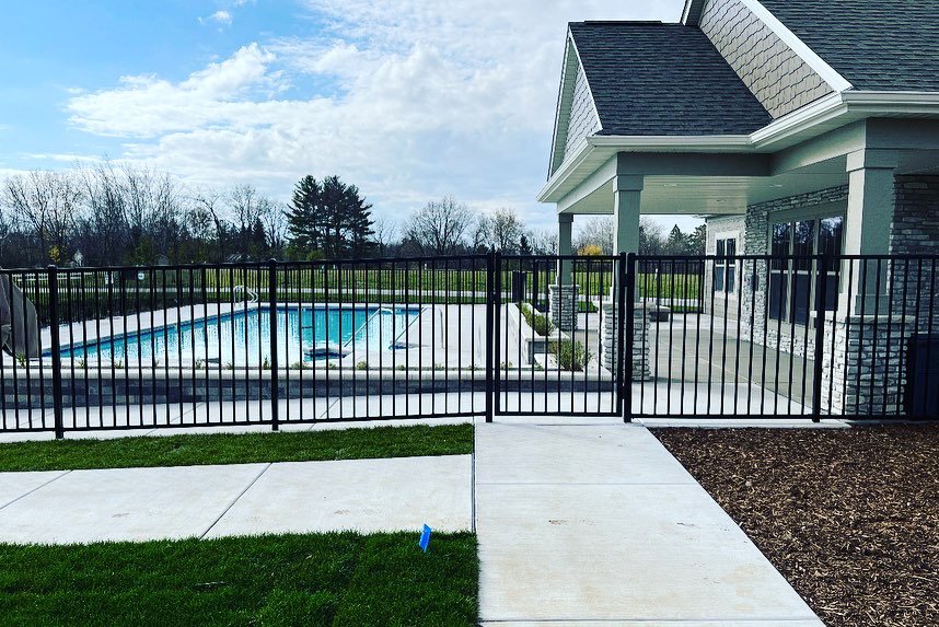 A black ornamental fence enclosing a swimming pool area, installed by Northway Fence in Menomonee Falls, WI.