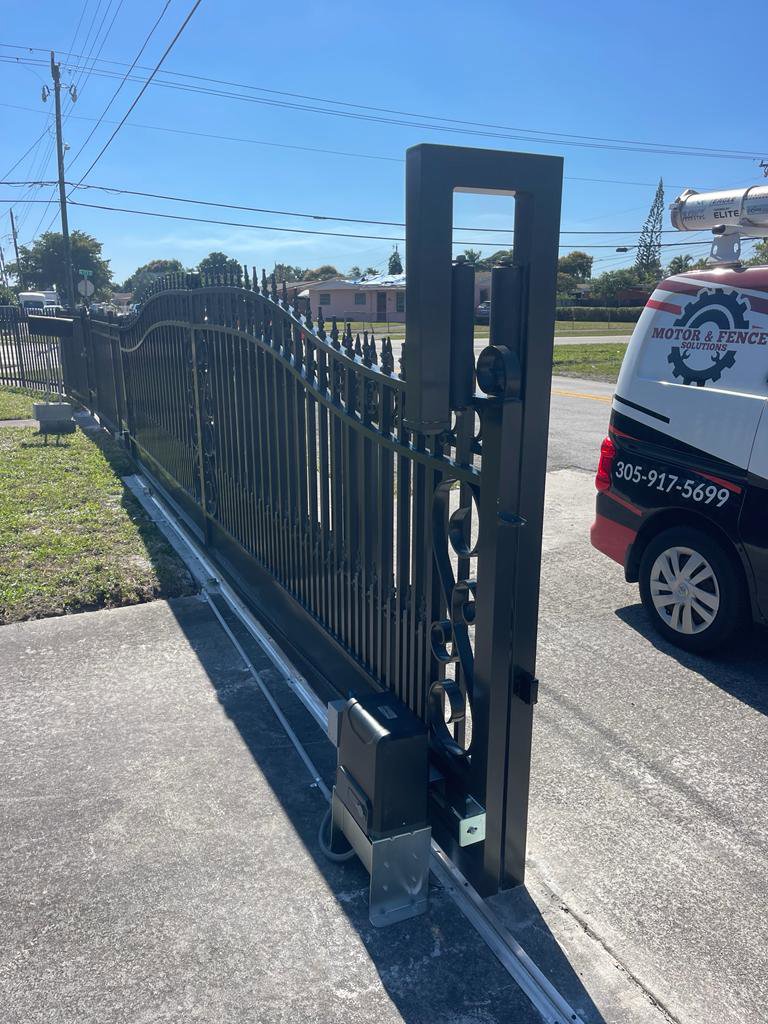 A black ornate sliding gate with a gate operator motor installed by Motor & Fence Solutions in Miami, FL.