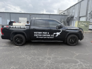 A black pest control truck with the Victory Pest & Critter Control logo and equipment in San Antonio, TX.
