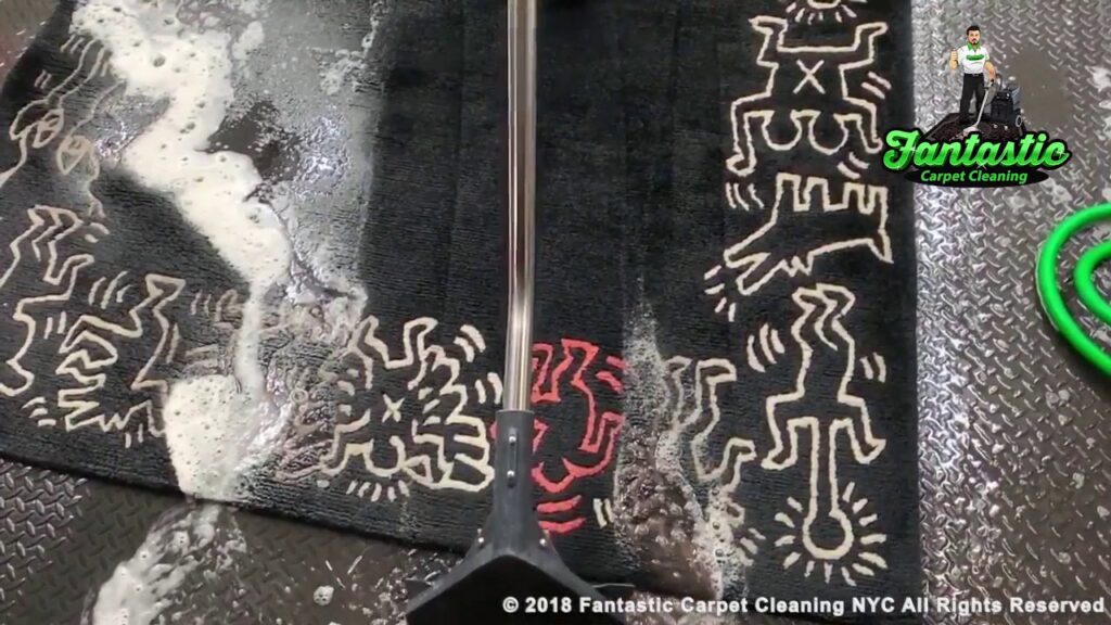 A black patterned rug being cleaned with a professional wand and foam by Fantastic Carpet Cleaning NYC in Ridgewood, NY