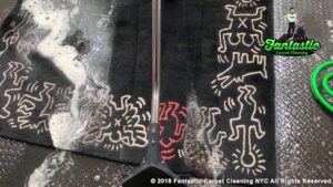 A black patterned rug being cleaned with a professional wand and foam by Fantastic Carpet Cleaning NYC in Ridgewood, NY