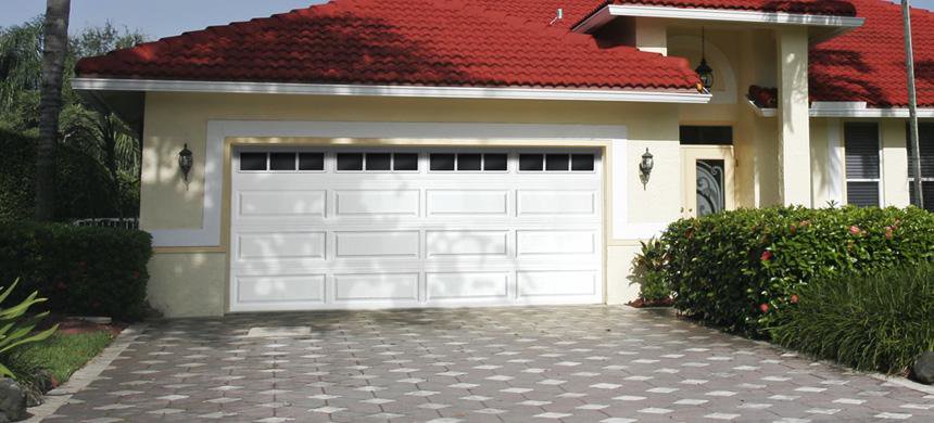 A newly installed black textured garage door on a brick house by Your Other Front Door LLC in Lakewood, CO.