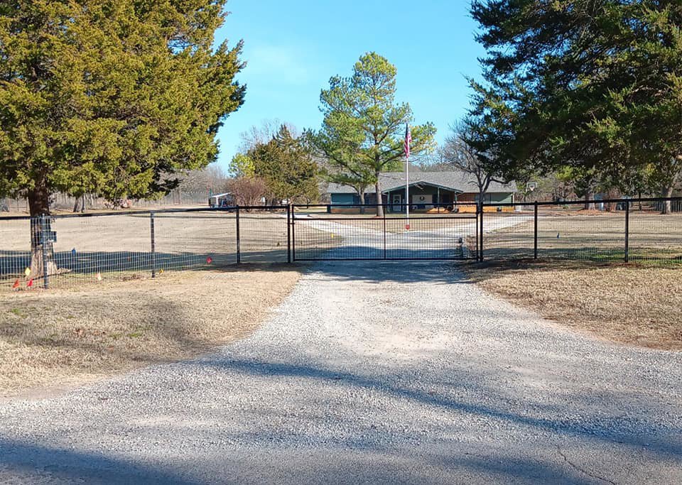A black wire fence with a double gate leading to a property by Veteran Fence Company LLC in Shawnee, OK.