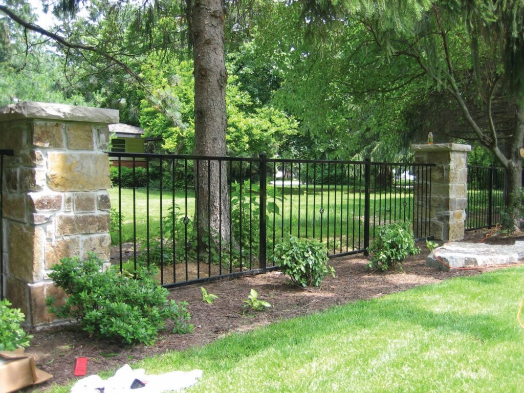 An elegant black wrought iron fence with decorative stone pillars by Freeman Fence in Atlanta, GA.