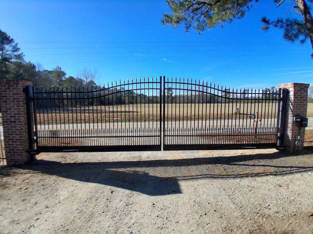 A large black wrought iron style gate with brick pillars installed by JB Nealy Fence in Elgin, SC.