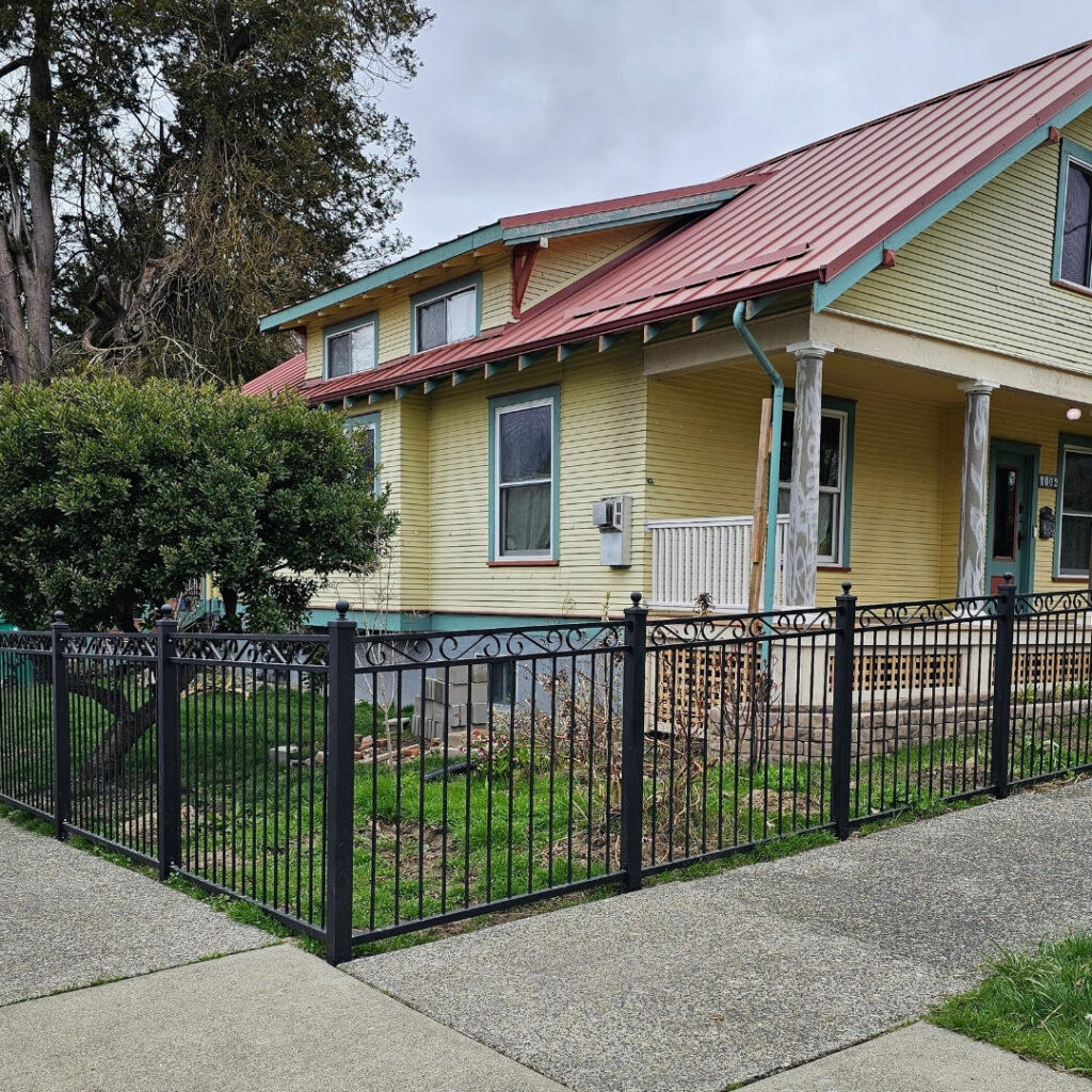 A classic black wrought iron style fence surrounding a residential property, installed by PNW FENCE in Lewiston, ID.