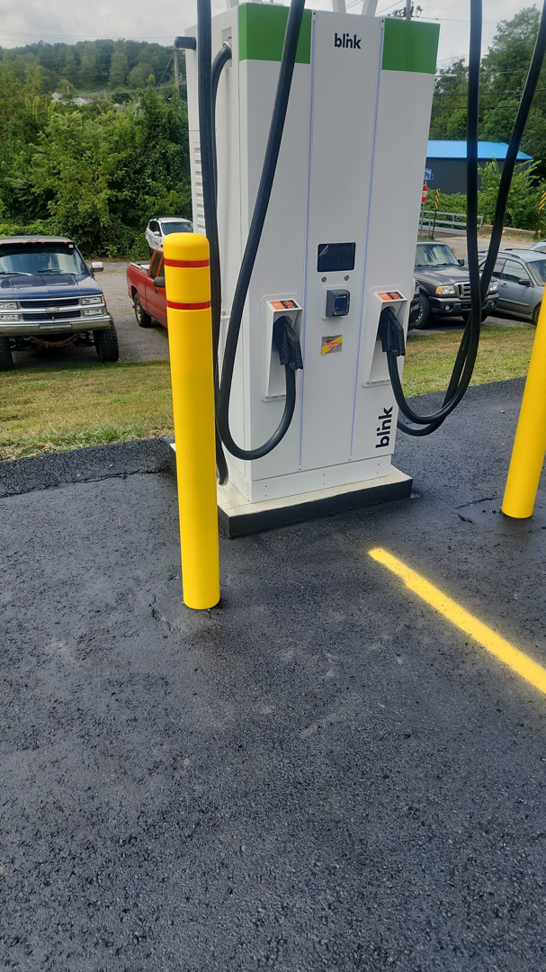 A Blink EV charging station with protective yellow bollards installed by Pittsburgh Electric & Maintenance in Pittsburgh, PA