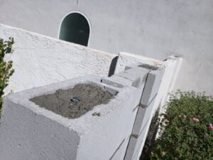 The top of a block wall fence being filled with concrete during construction by Arce Masonry LLC in Glendale, AZ