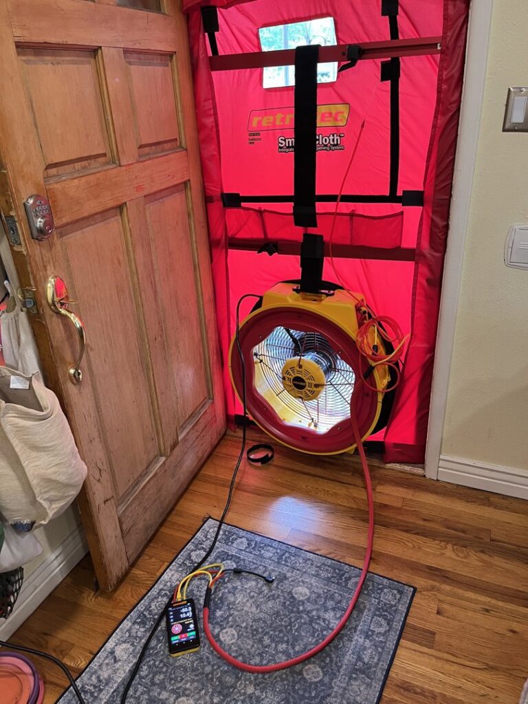 A blower door test in progress, part of an energy audit by Just Heat Pumps to improve home efficiency in Denver, CO.