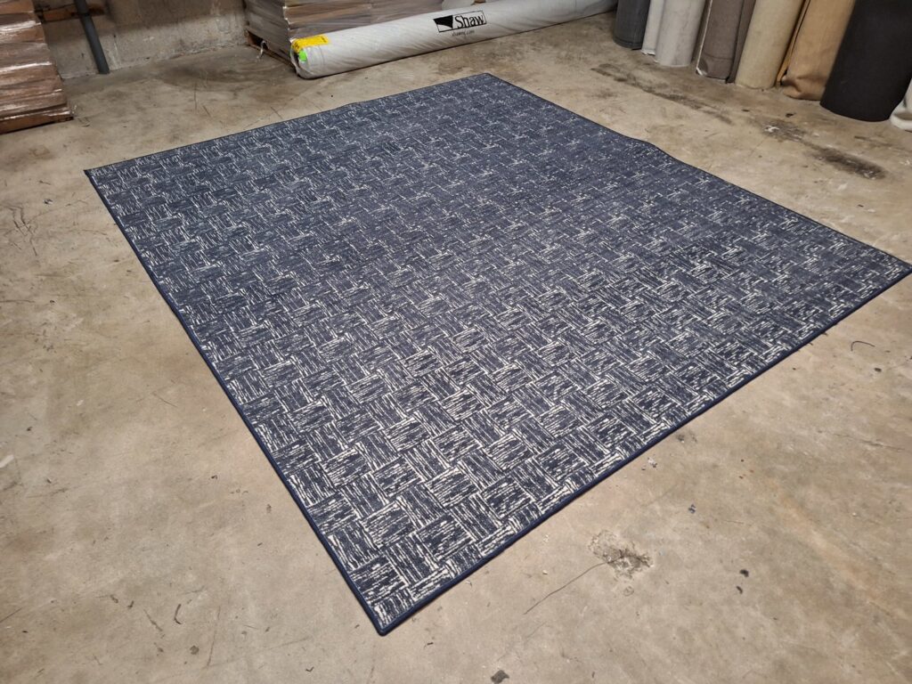 A large blue and white patterned carpet sample displayed by Palmetto Carpet Company in Miami, FL.