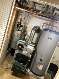 A boiler and grey hot water heater installation with copper piping by JLP Heating & Cooling in Norwalk, CT