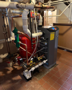 A newly installed boiler and intricate piping system in a utility room by Voegeli Heating & A/C, Inc. in Toledo, OH.