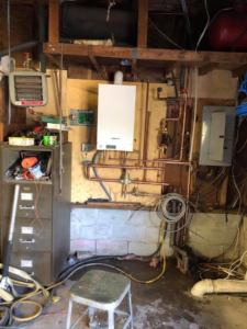 HVAC setup with a boiler, copper piping, and radiant heater installed by Ausoli Grace Plumbing & Hvac in South Portland, ME.